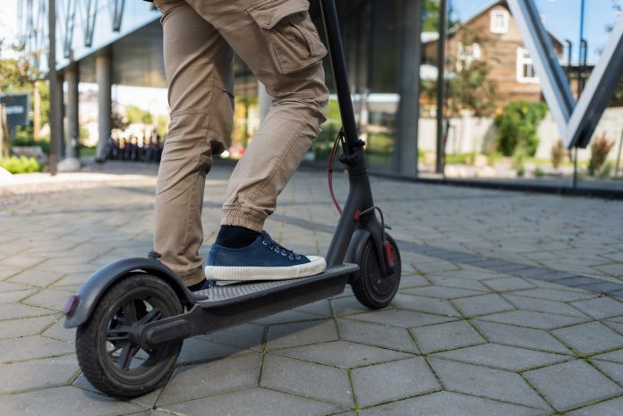 Osoba koja vozi električni romobil.