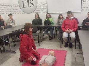 Članica Crvenog križa demonstrira učenicima proces oživljavanja na lutki.