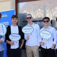 Srednjoškolci stoje ispred plakata Dana Europe.