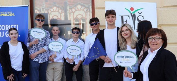 Srednjoškolci i jedna gospođa stoje ispred plakata ETŠ-a i Dana Europe.