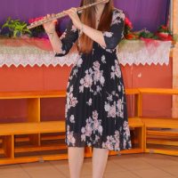 Ženska osoba svira flautu.