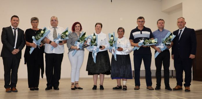 Osobe koje su primile priznanja poziraju za fotografiju s cvijećem u rukama
