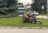 Muška osoba na traktorskoj kosilici uređuje travnatu površinu