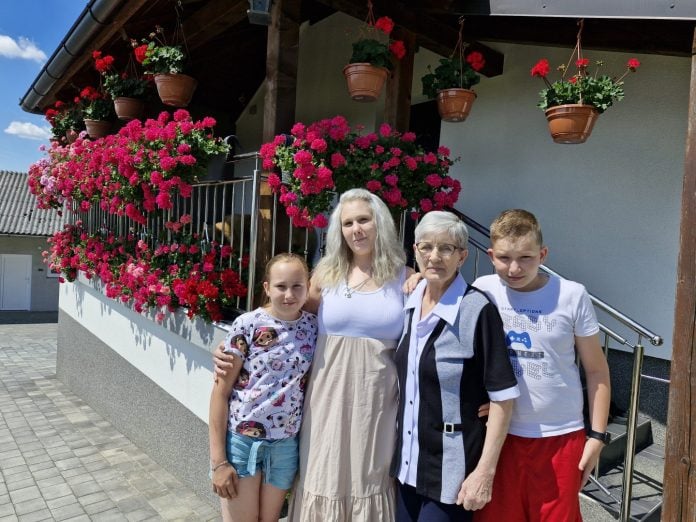 valentina Novak s obitelji ispred balkona duplih pelargonia