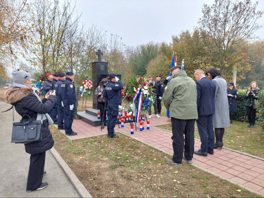 Ljudi, članovi policije, vojske odaju počast preminulima