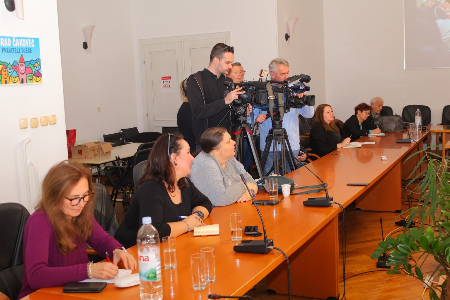 Snimatelji i mediji za stolom sjede.