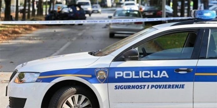Prometna - policijski auto, u pozadini je policijska traka.
