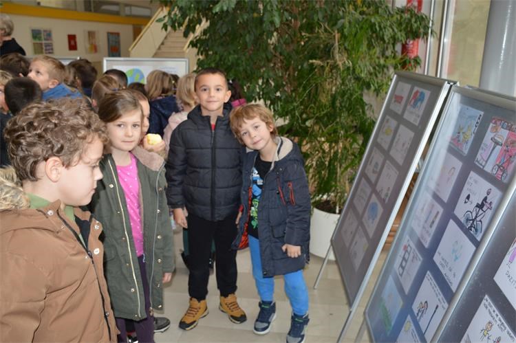 Djeca gledaju izložebe crteže u hodniku škole