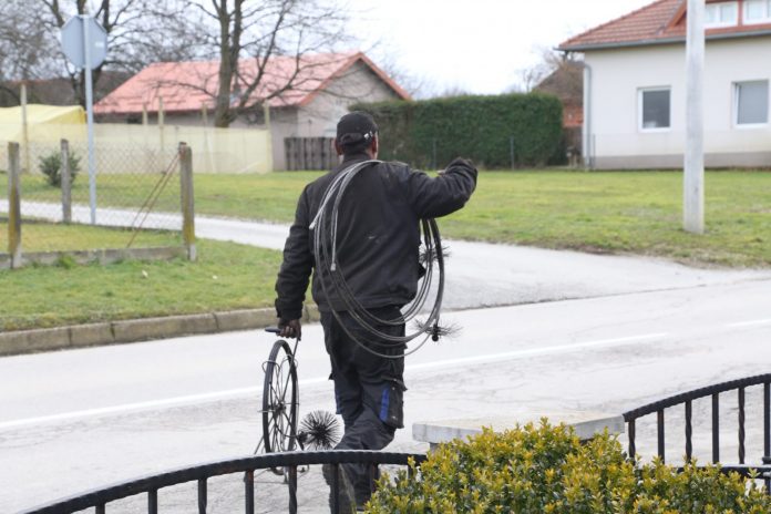 dimnjačar na cesti okrenut leđima