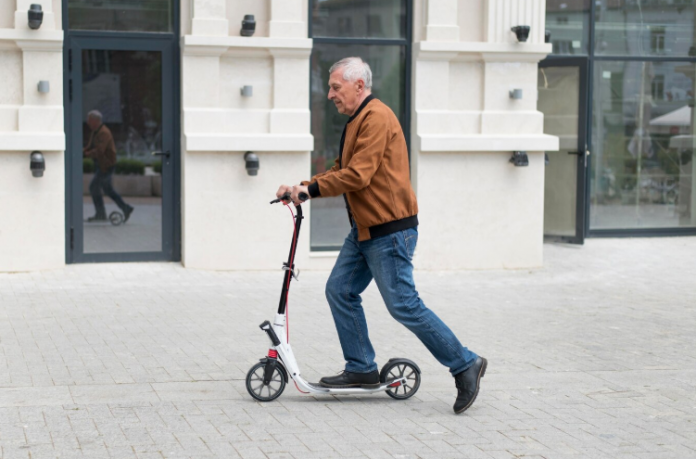 starija osoba vozi električni romobil, deda na romobilu