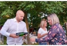 Na slici su muškarac i žena na dočeku ljeta na vidikovcu Mađerkin breg, muškarac toči vino u čašu